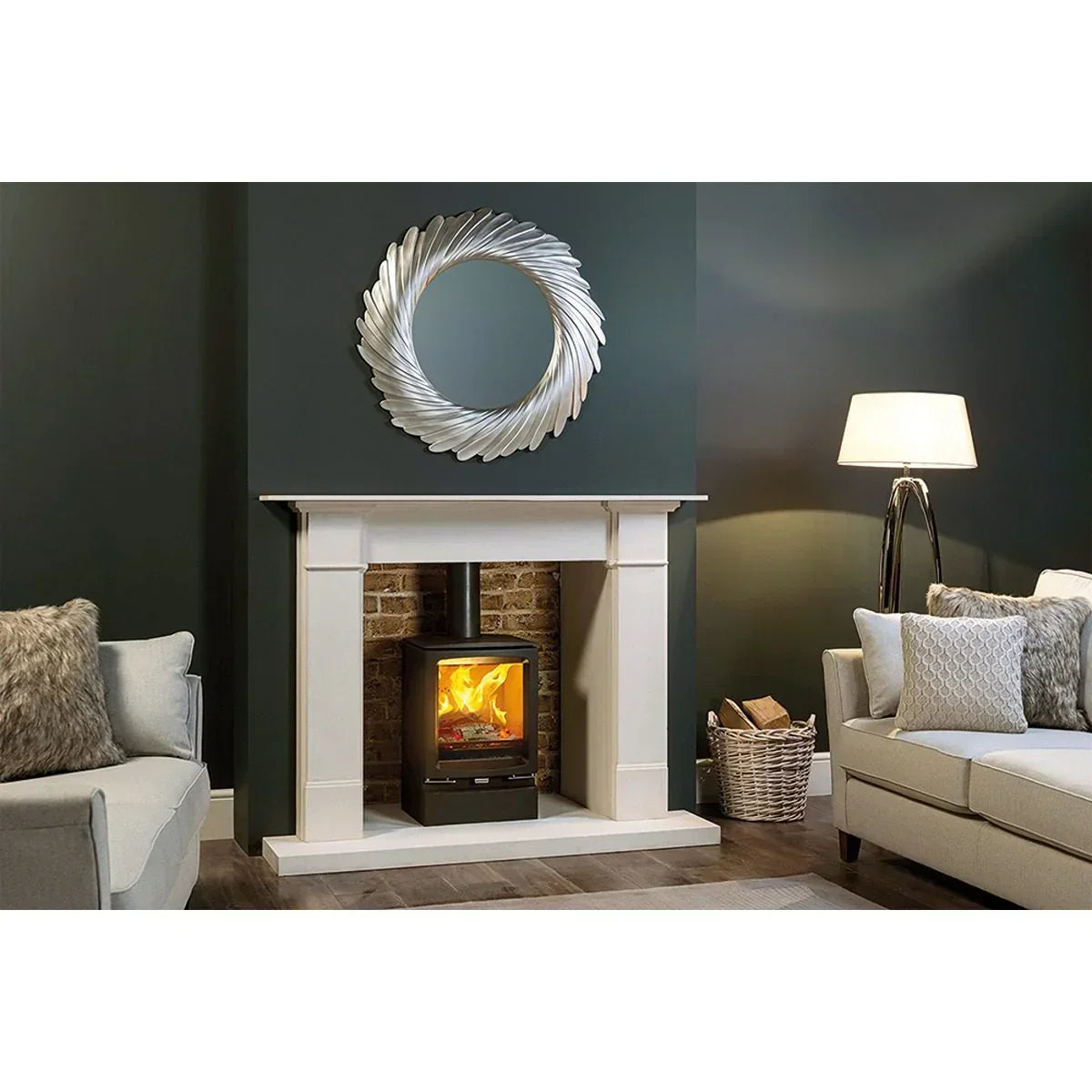 Modern living room with white fireplace, wood burning stove, grey sofas and round wall mirror