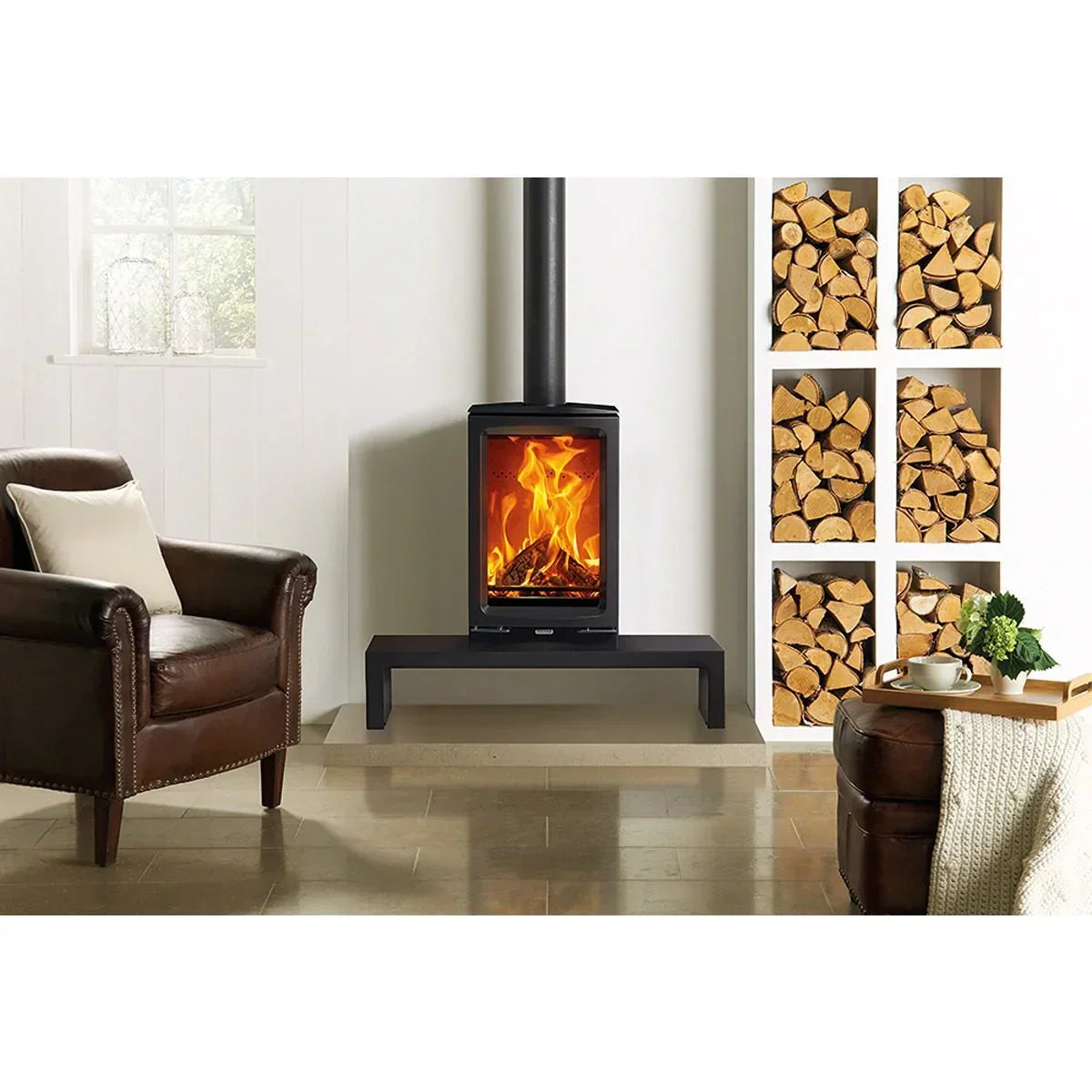 Modern wood burning stove with glass door in living room, firewood stacked beside