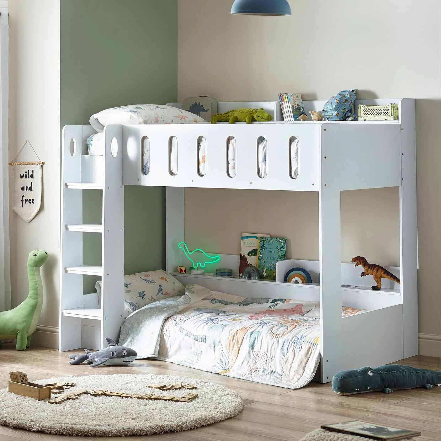 White wooden bunk bed in kids’ room with dinosaur bedding and ladder