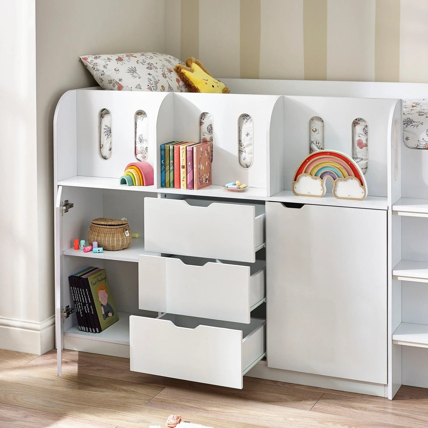 White children's storage bed with drawers, bookshelves, toys, and rainbow decor