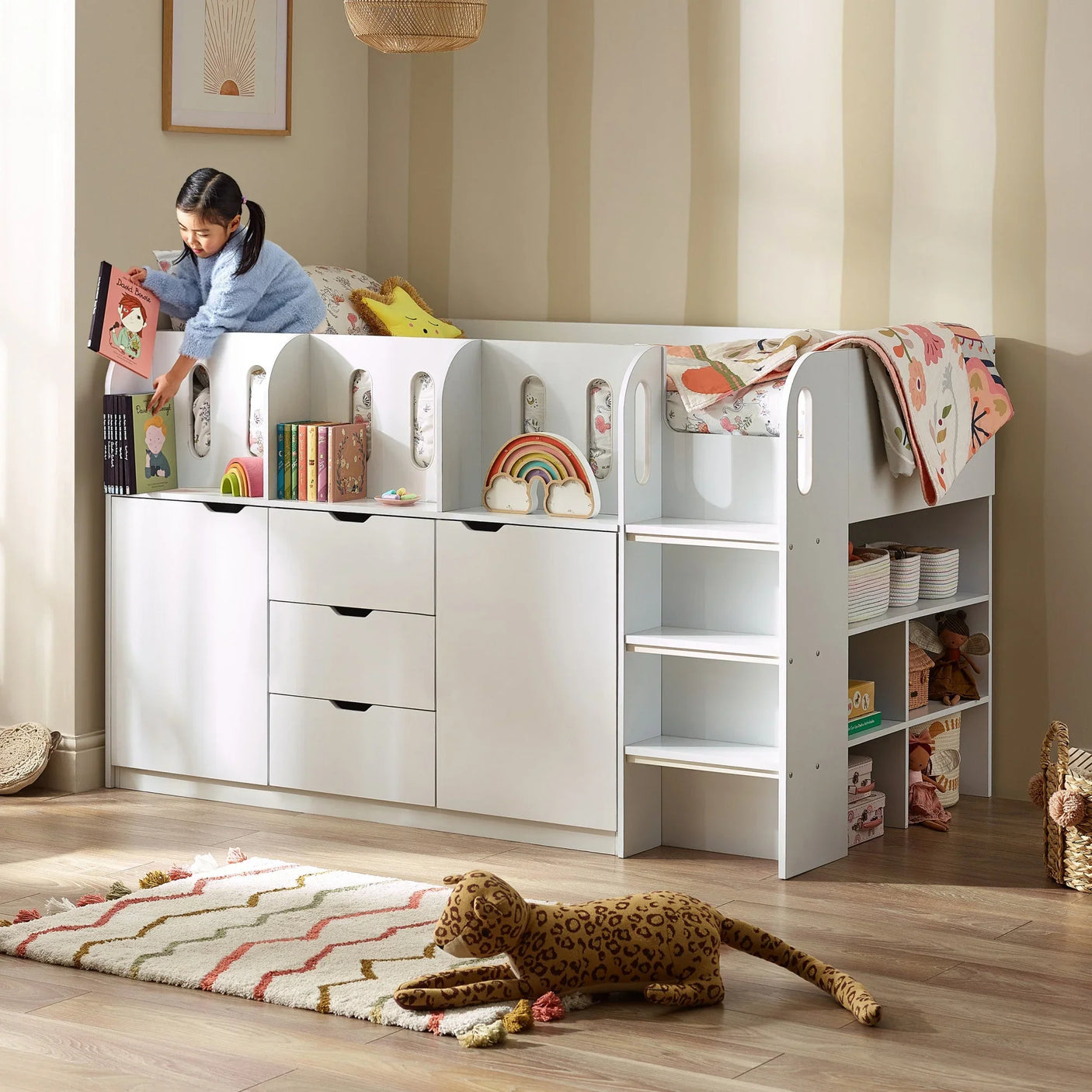 White kids cabin bed with integrated storage, shelves, drawers and stairs in playroom