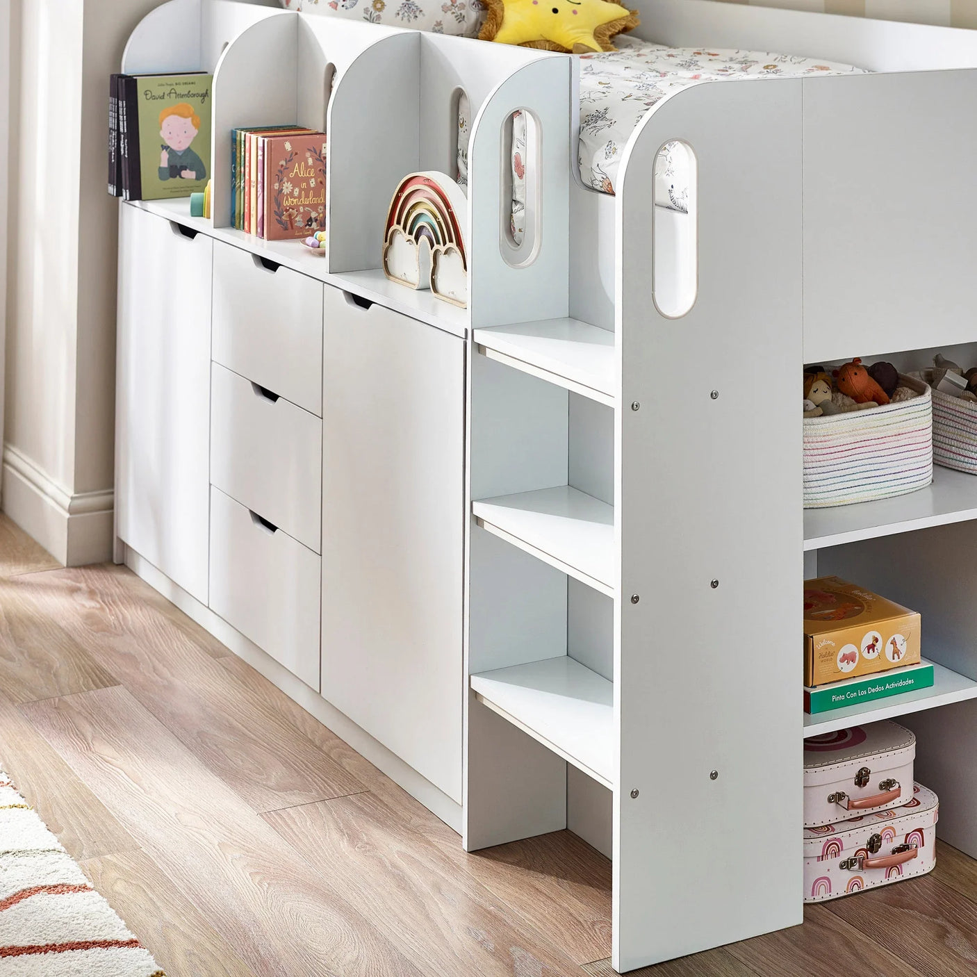 White kids storage bed with bookshelves, drawers, and steps in a children’s bedroom