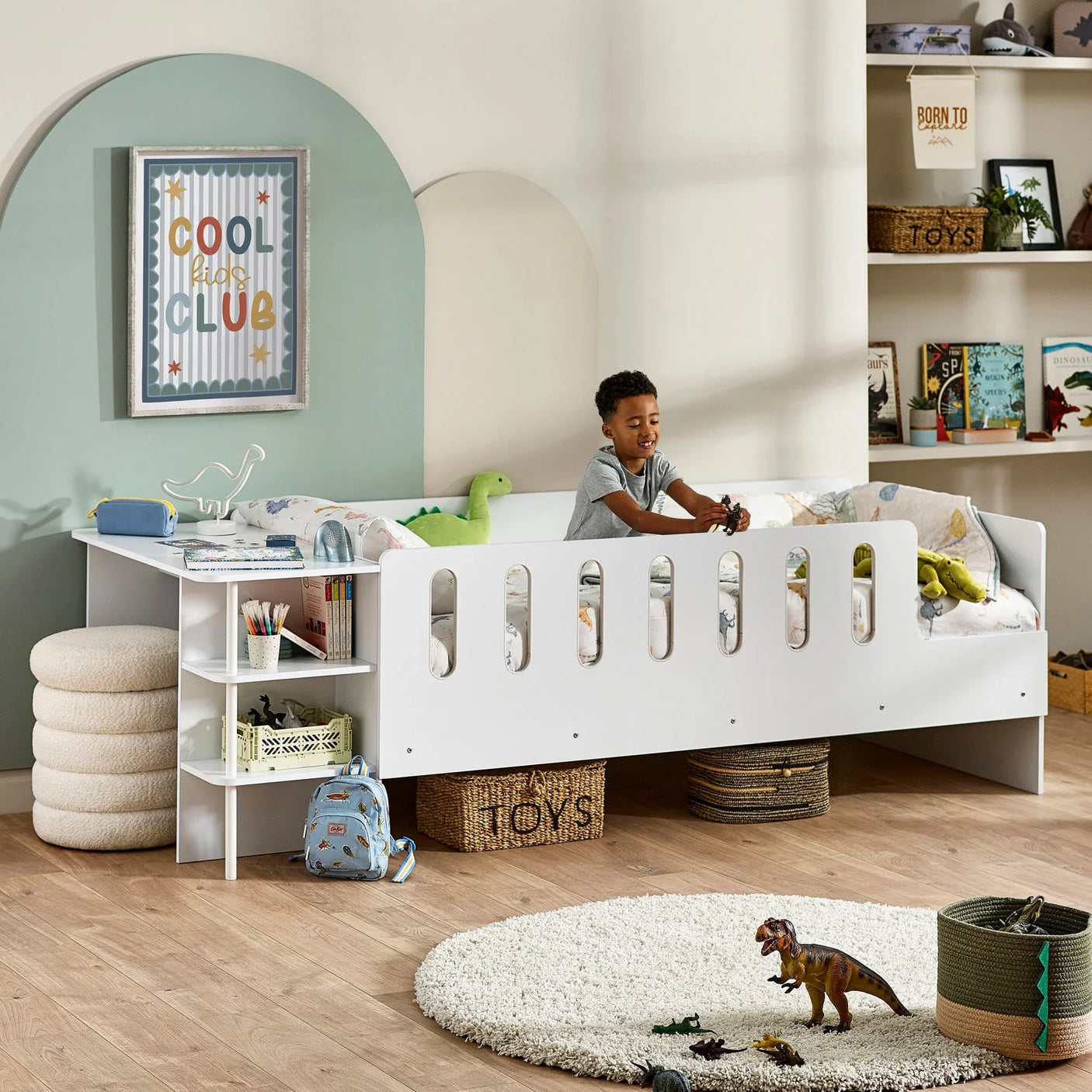 White kids bed with built-in desk and storage shelves in a tidy bedroom setting