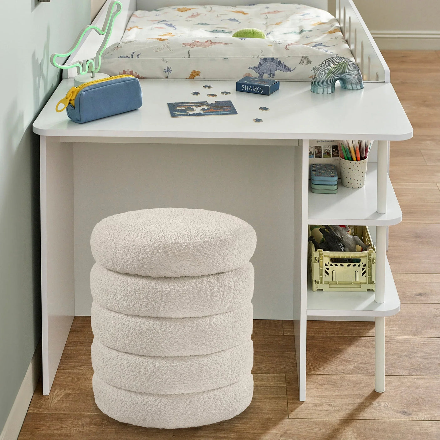 White boucle kids stool beside white desk with shelves and storage under loft bed