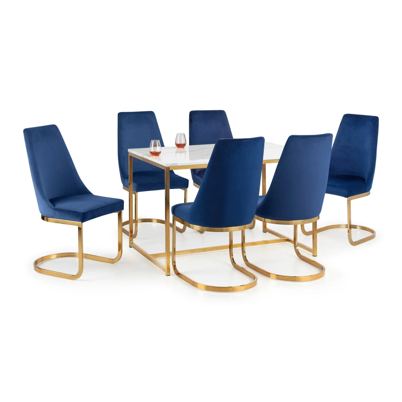Marble dining table set with gold frame and six blue velvet chairs, two glasses on tabletop