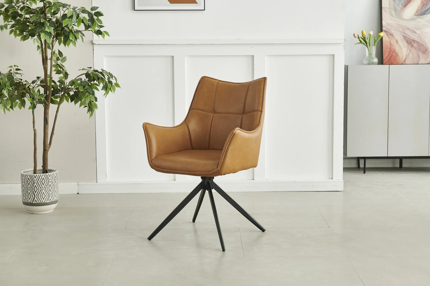 Tan leather dining chair with black metal legs in modern room setting