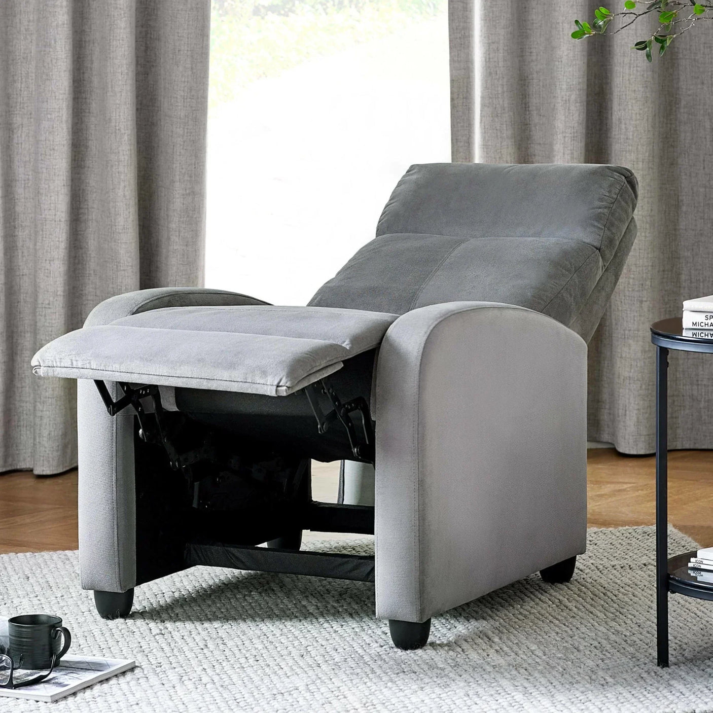 Grey fabric recliner chair with footrest extended in a modern living room corner
