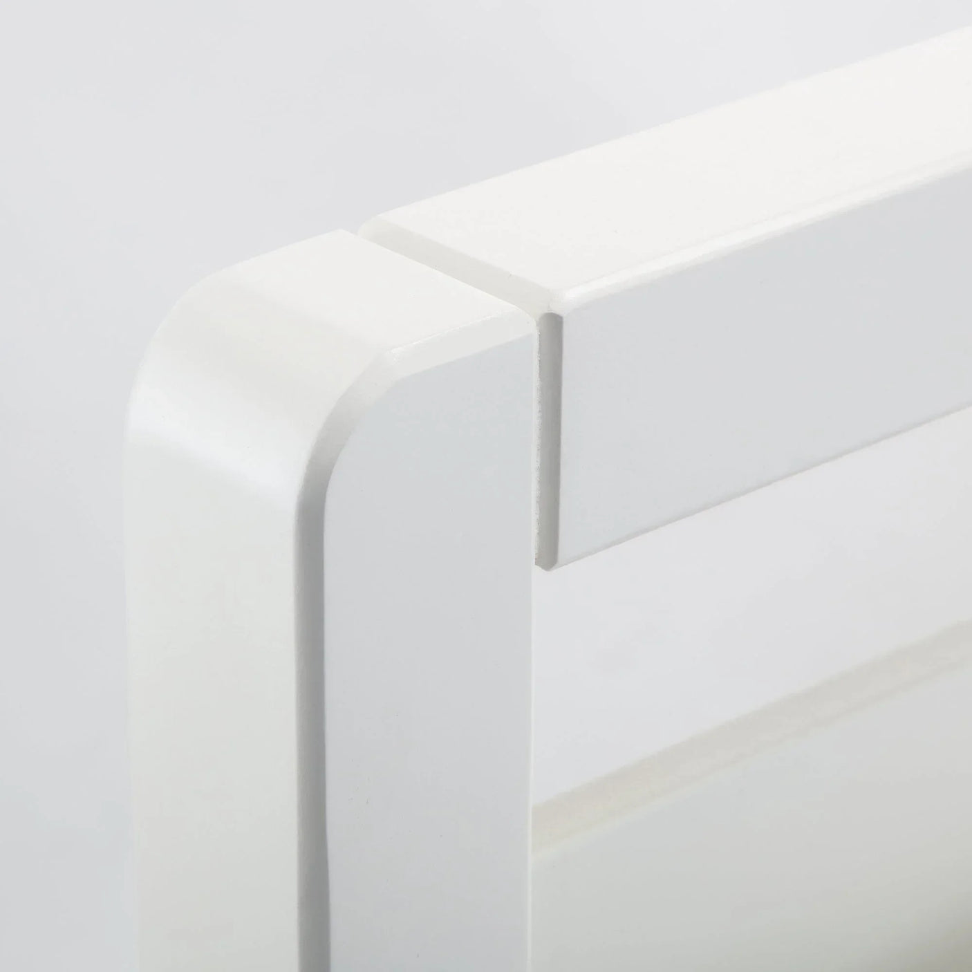 White wooden bed headboard with modern square edge detail close-up