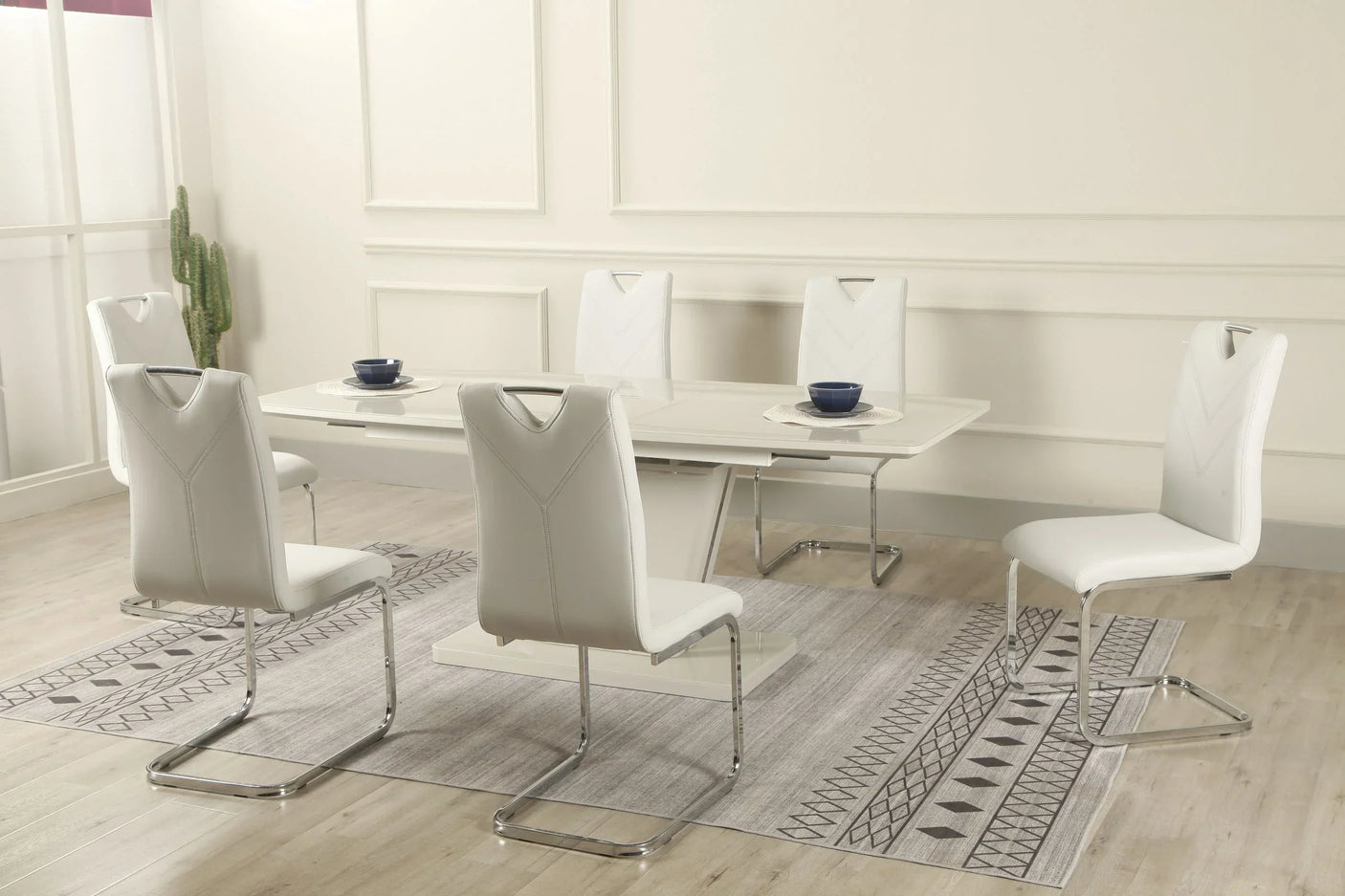 White extension dining table with six matching faux leather chairs in modern dining room