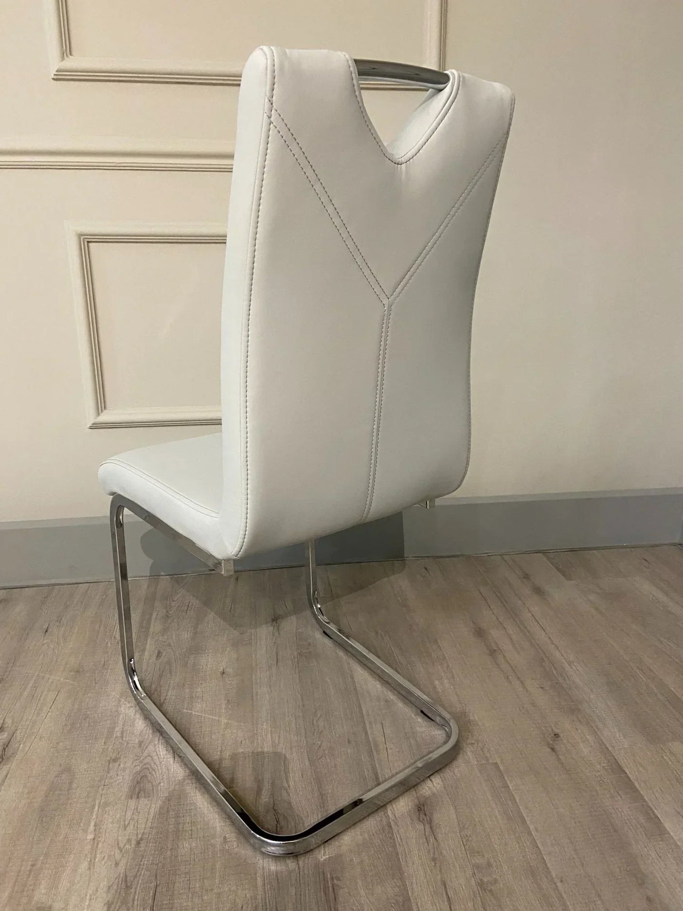 White leather dining chair with chrome cantilever legs and stitched back detail