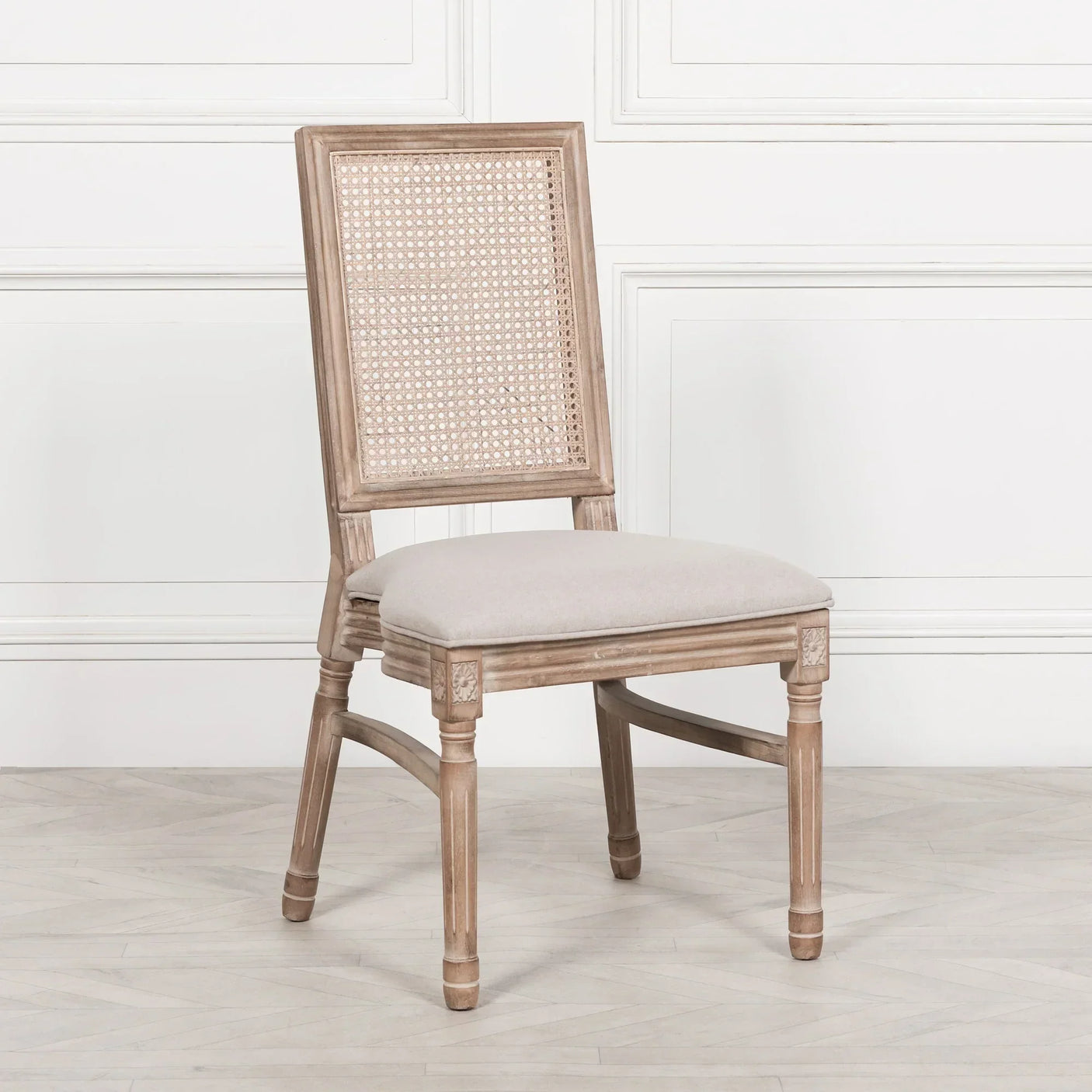 Wooden dining chair with rattan backrest and cushioned seat on light patterned floor