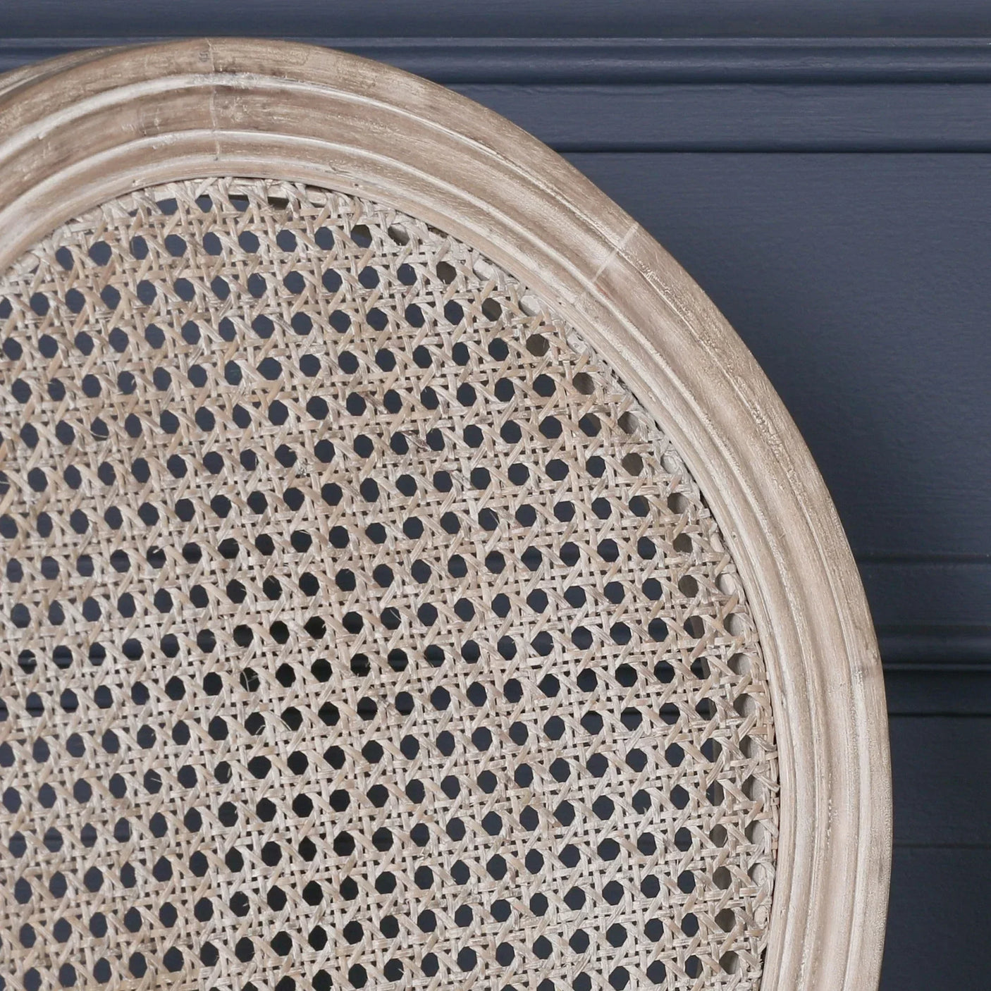 Close up of round rattan dining chair backrest with natural wood frame