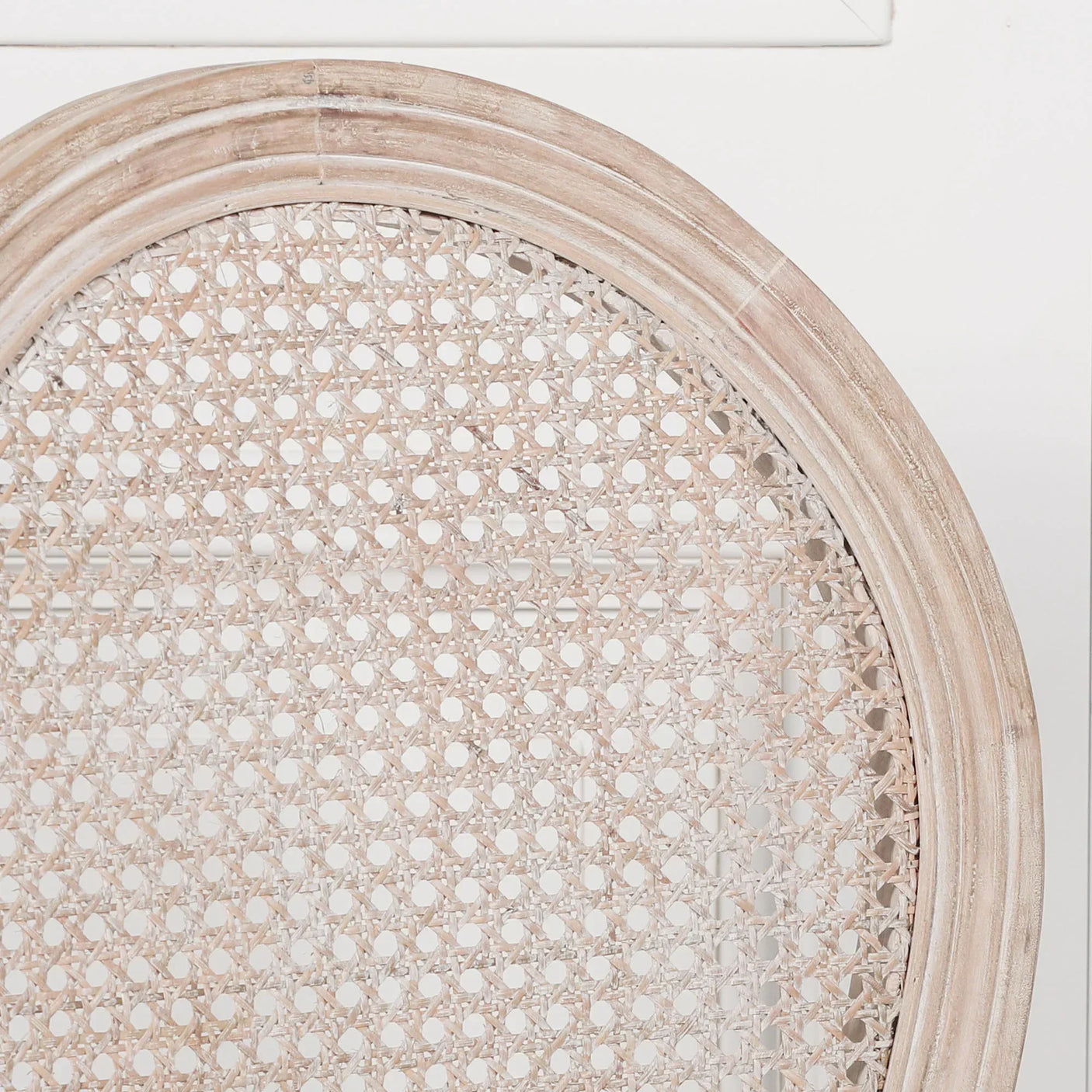 Close up of natural cane dining chair backrest with light wood frame