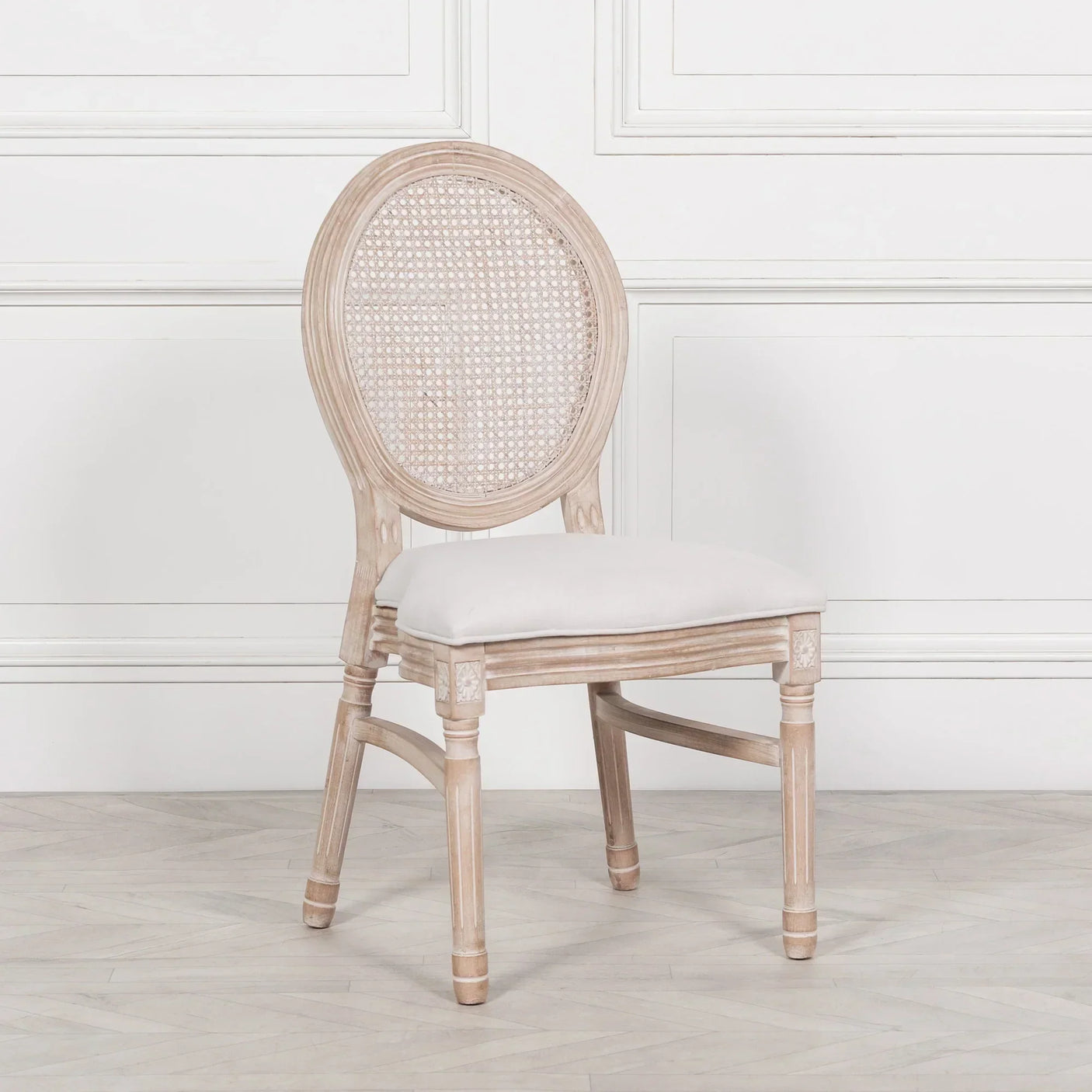 Oak dining chair with rattan backrest and cushioned seat on light wood floor