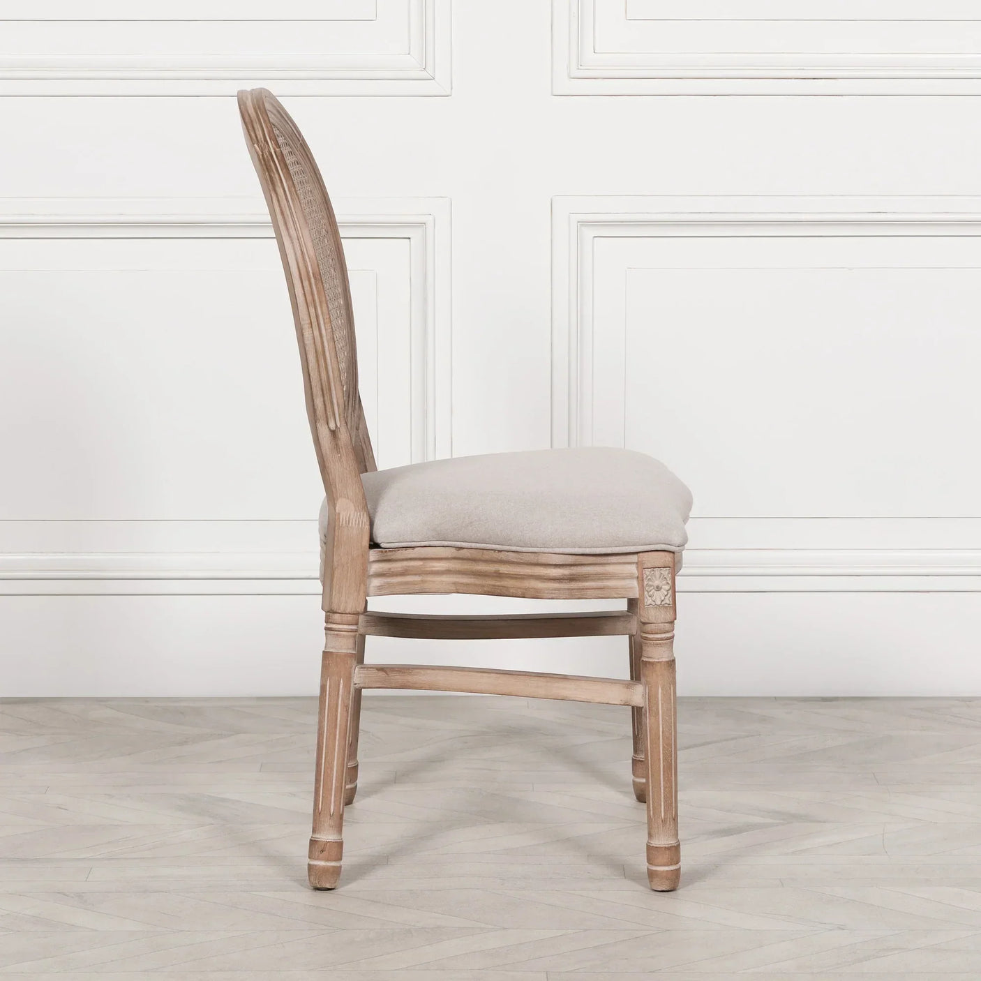 Side view of wooden dining chair with upholstered seat and cane backrest