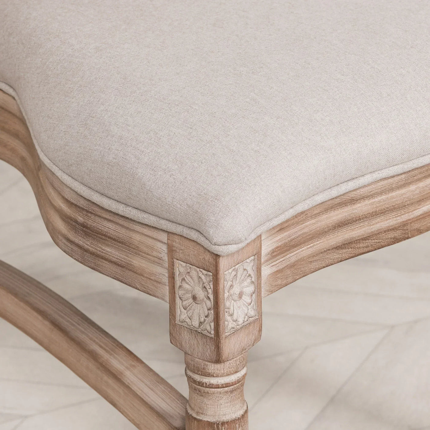 Beige upholstered dining chair seat with carved wooden frame and floral detail