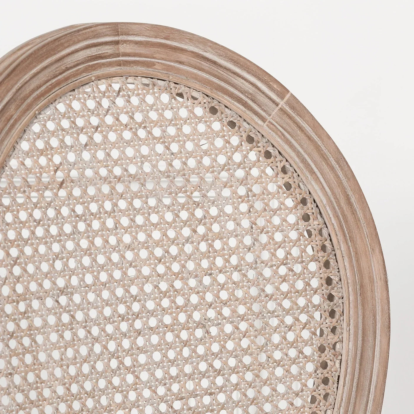 Natural rattan dining chair back with rounded wooden frame, close up detail