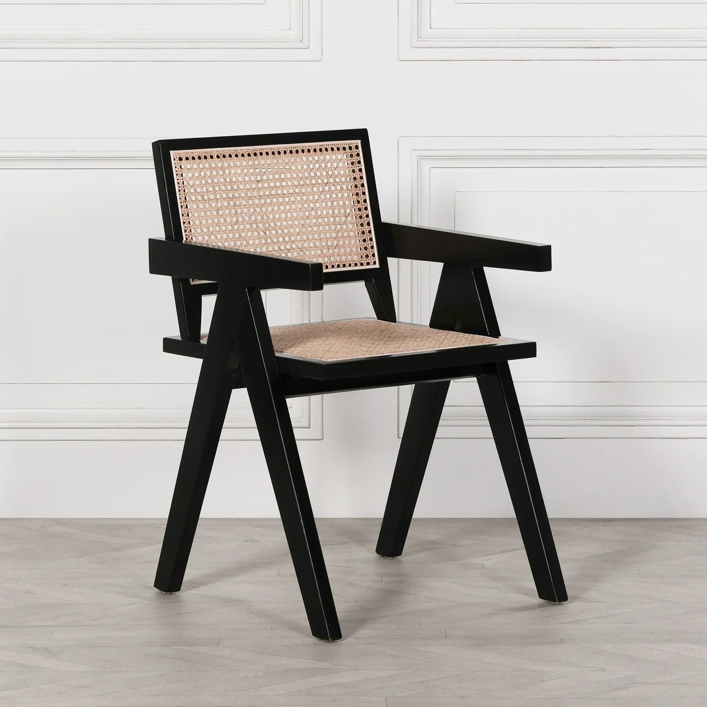 Black wooden accent chair with woven cane seat and backrest on hardwood floor