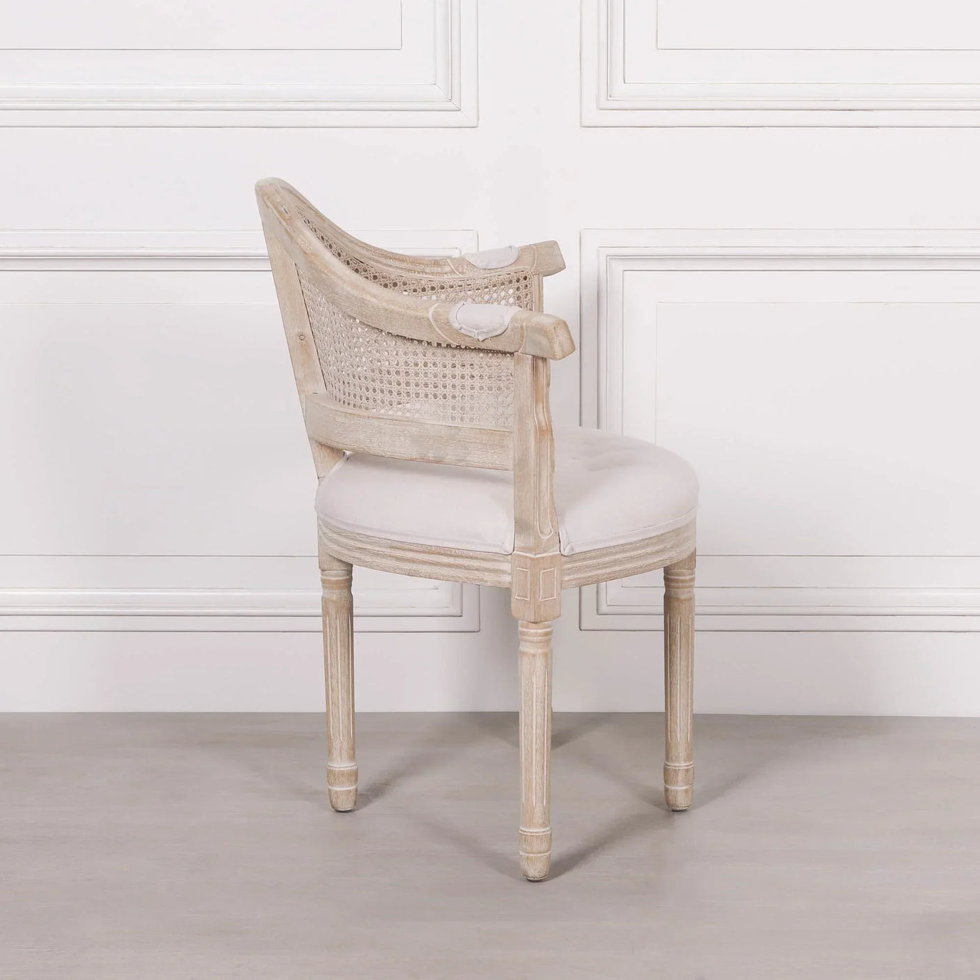 Light wood dining chair with round cushioned seat and rattan backrest