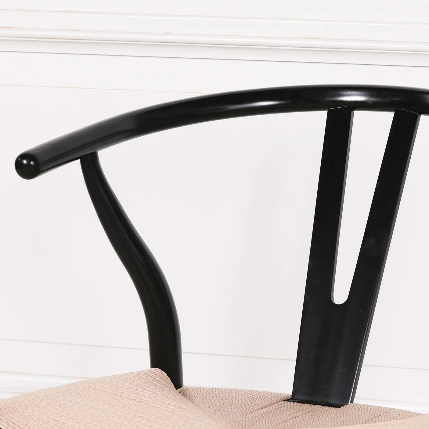Black wooden chair backrest and armrest with light beige woven seat detail