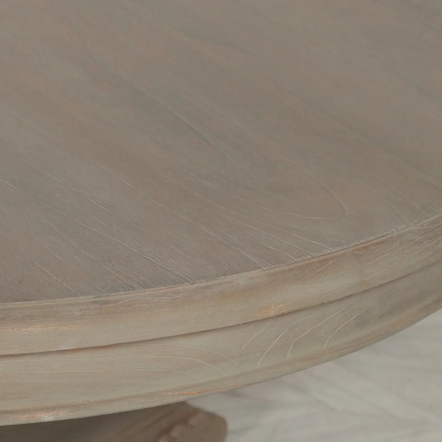 Closeup of round wood dining table with natural grain and light oak finish