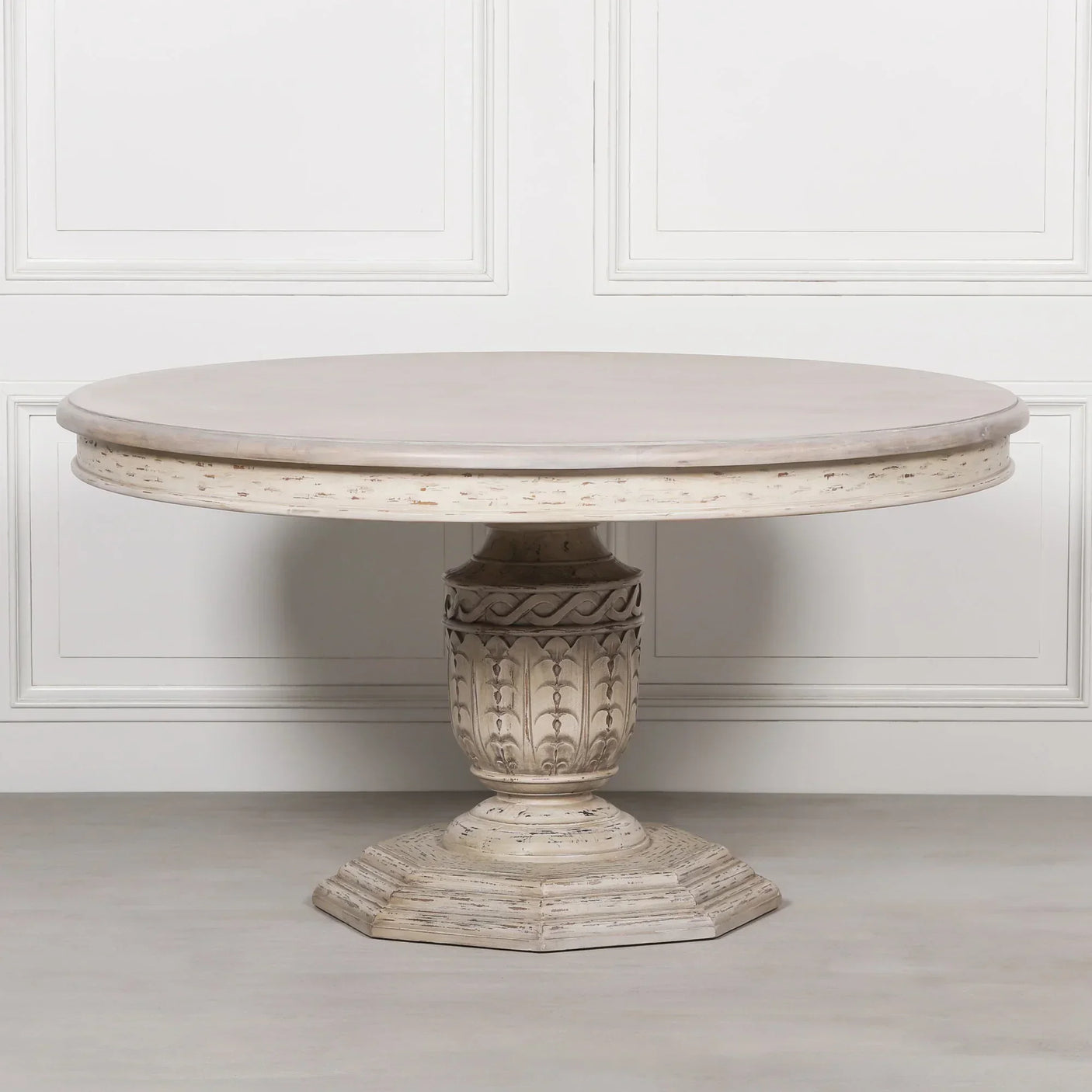 Round distressed wood dining table with ornate carved pedestal base