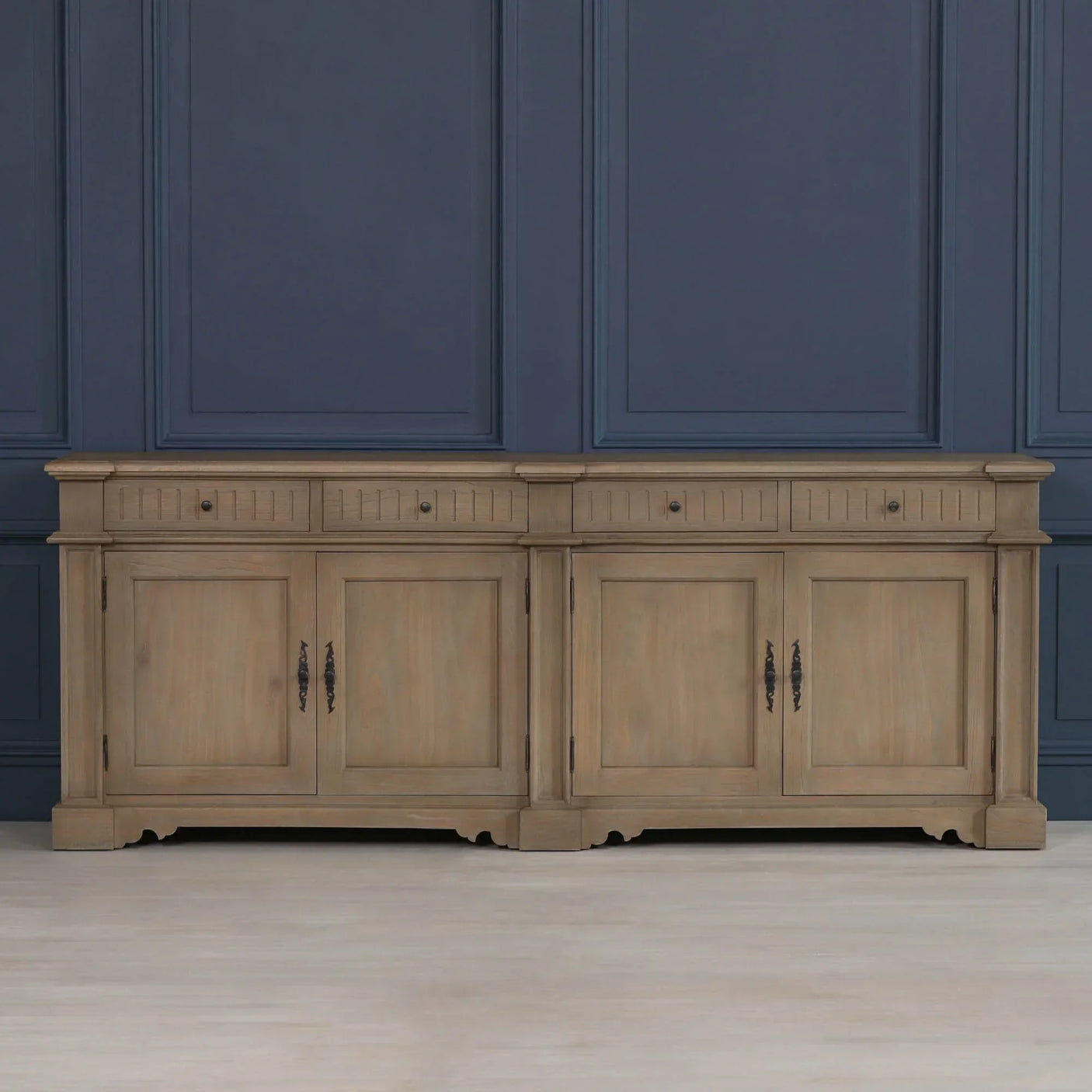Pair of oak sideboards with drawers and paneled doors against blue paneled wall
