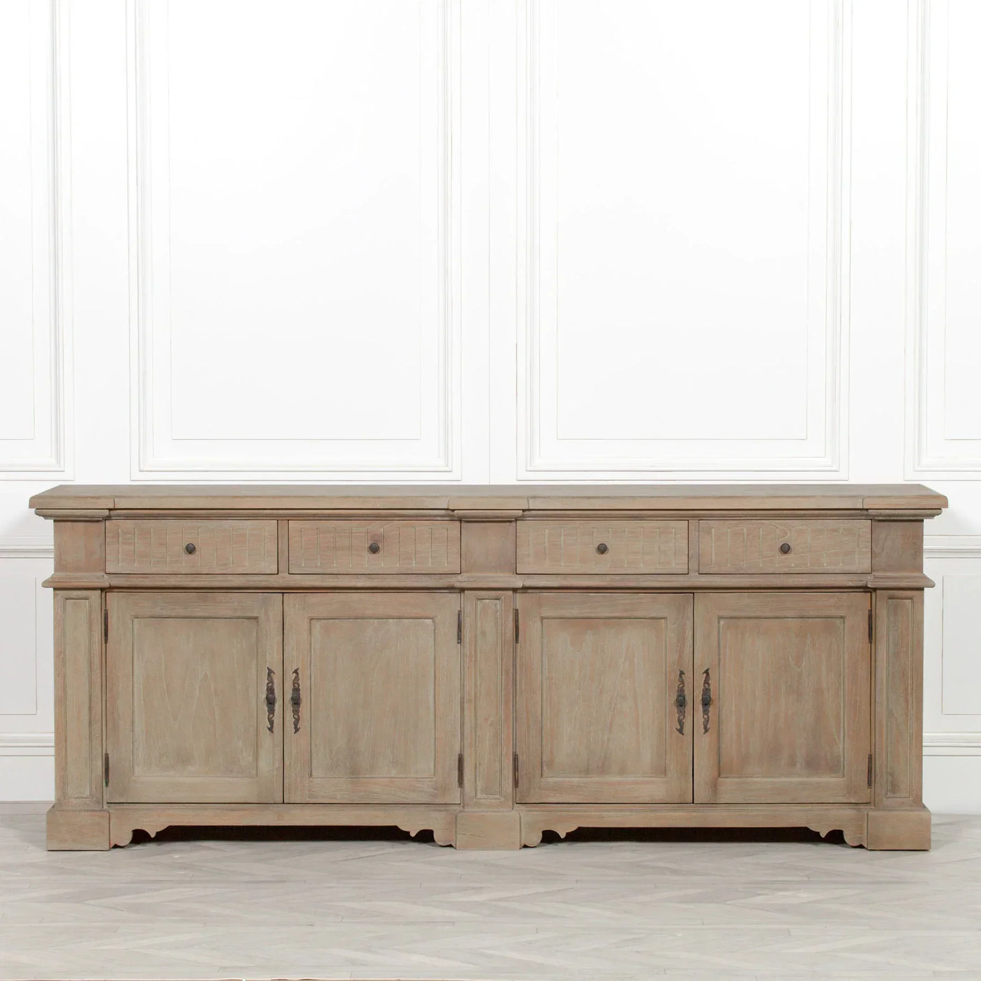 Oak sideboard with four drawers and four doors, antique handles, pictured against white wall