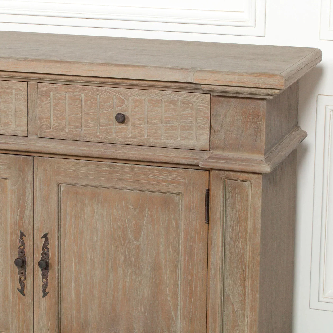 Light wood sideboard cabinet with decorative drawer and metal handles, close corner view