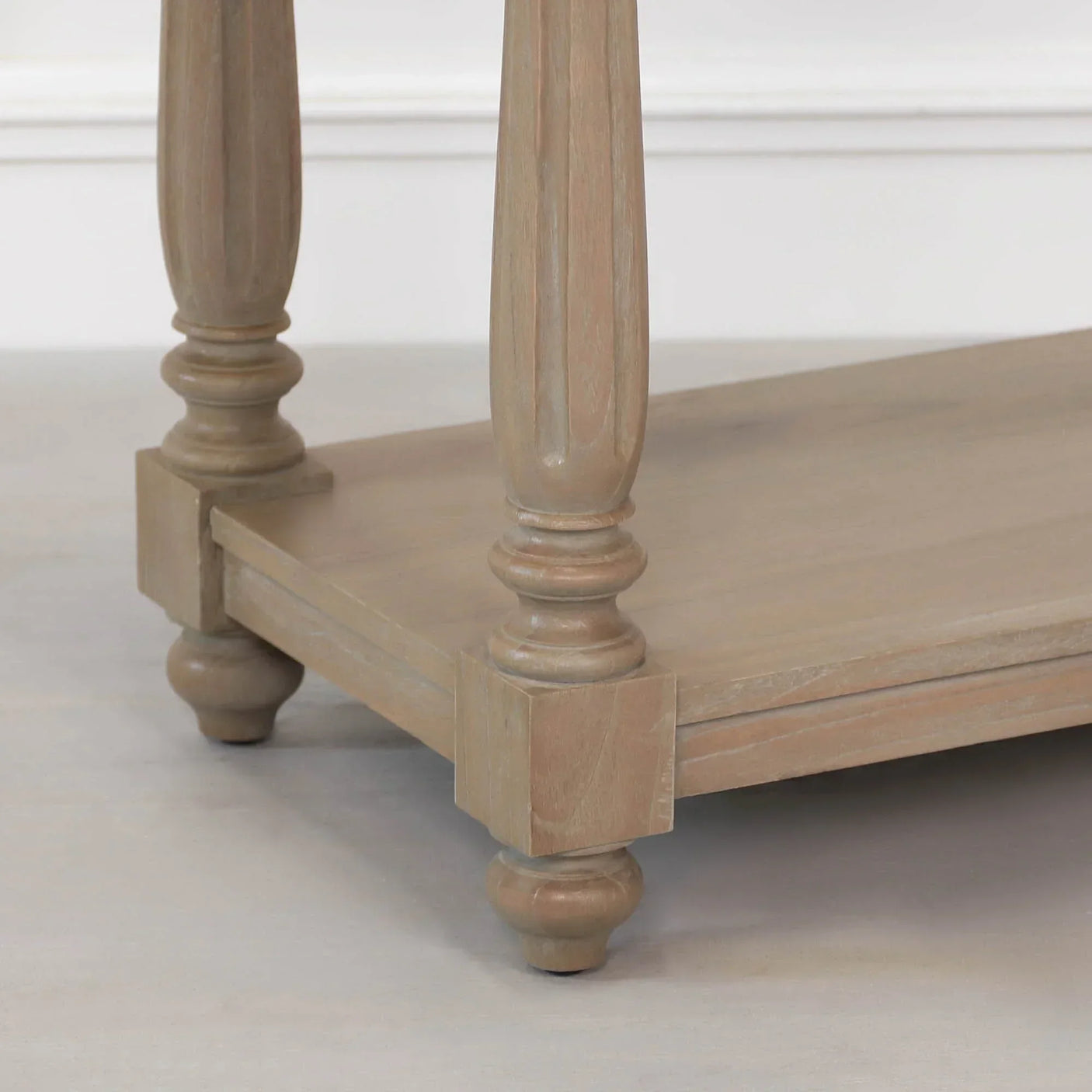 Wooden coffee table leg with turned design and lower shelf in natural finish