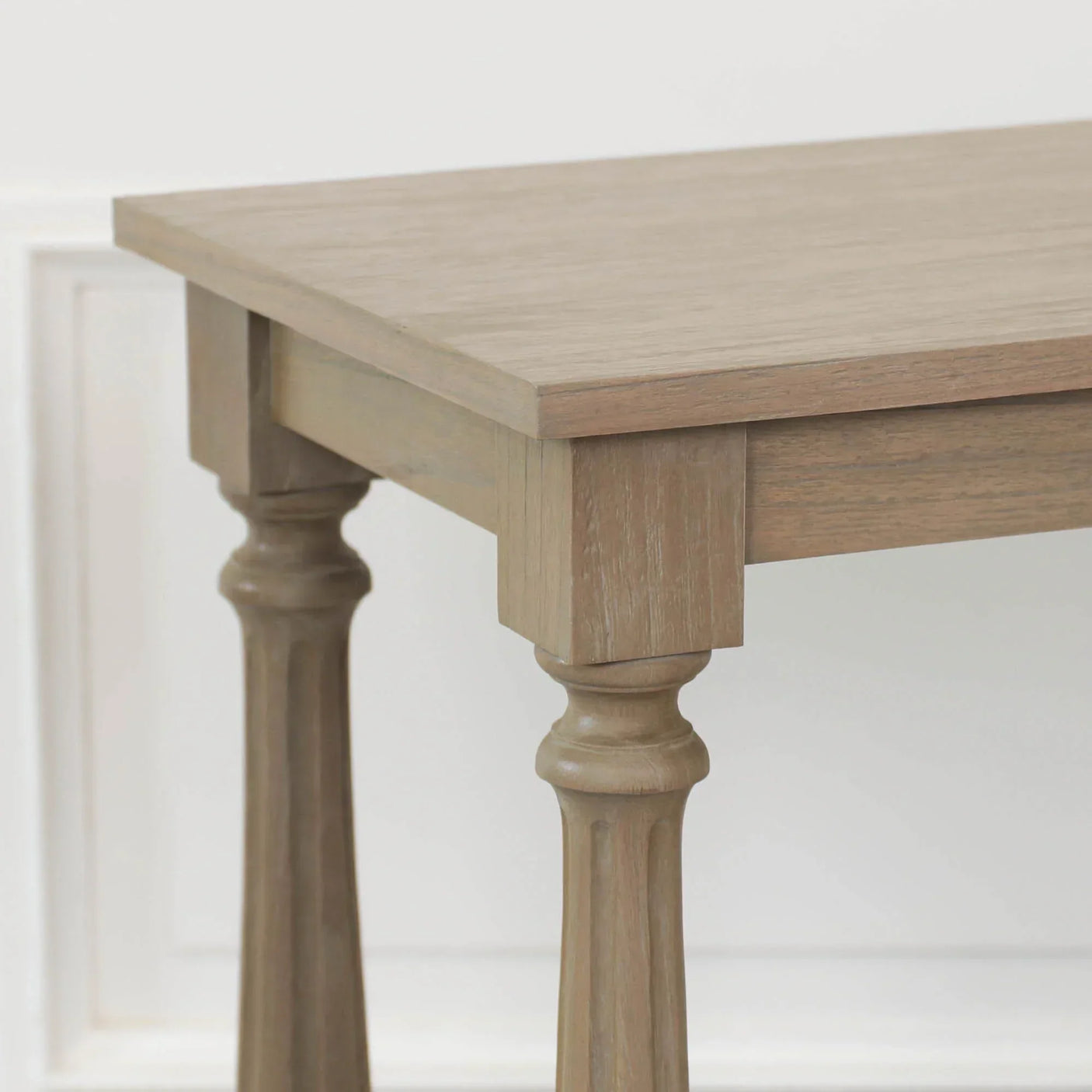 Oak dining table corner with carved wooden legs and light natural finish