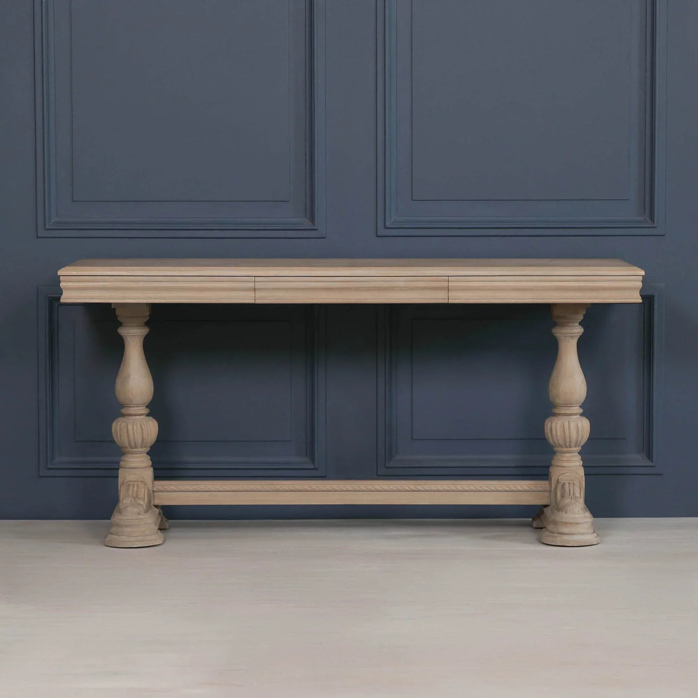 Solid wood console table with carved legs against dark panelled wall