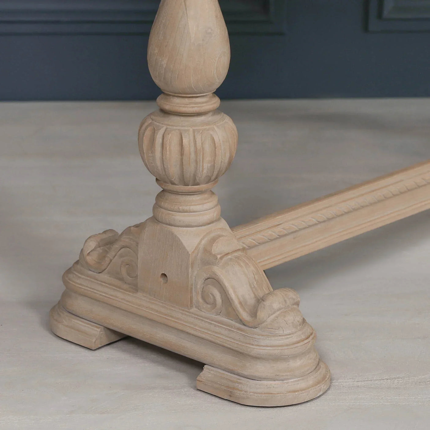 Carved wood dining table pedestal base with ornate detailing and light oak finish
