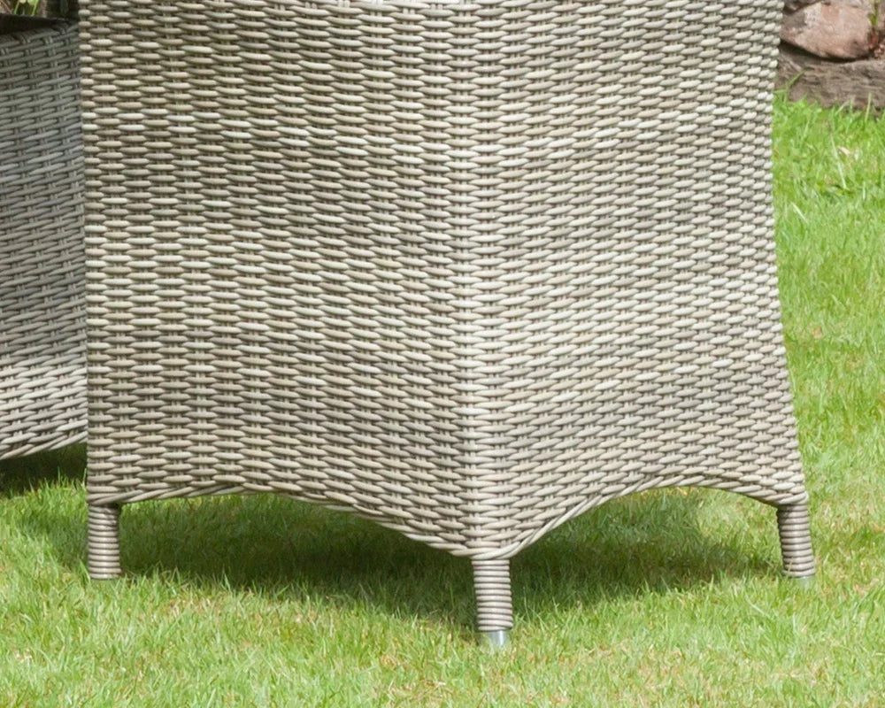 Close-up of grey rattan garden furniture legs and weave detail on grass