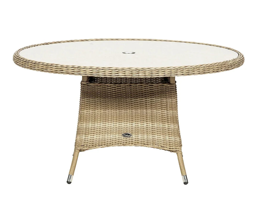 Round rattan garden table with glass top and central umbrella hole, beige wicker finish