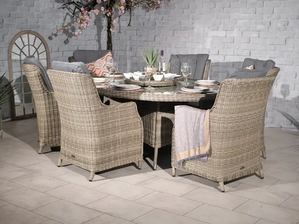 Rattan outdoor dining set with cushioned chairs and round table set for six
