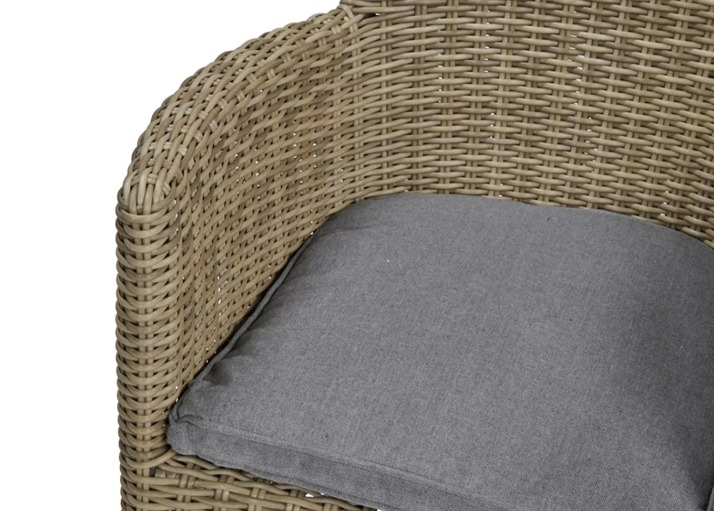Close-up of rattan armchair with curved armrest and grey seat cushion