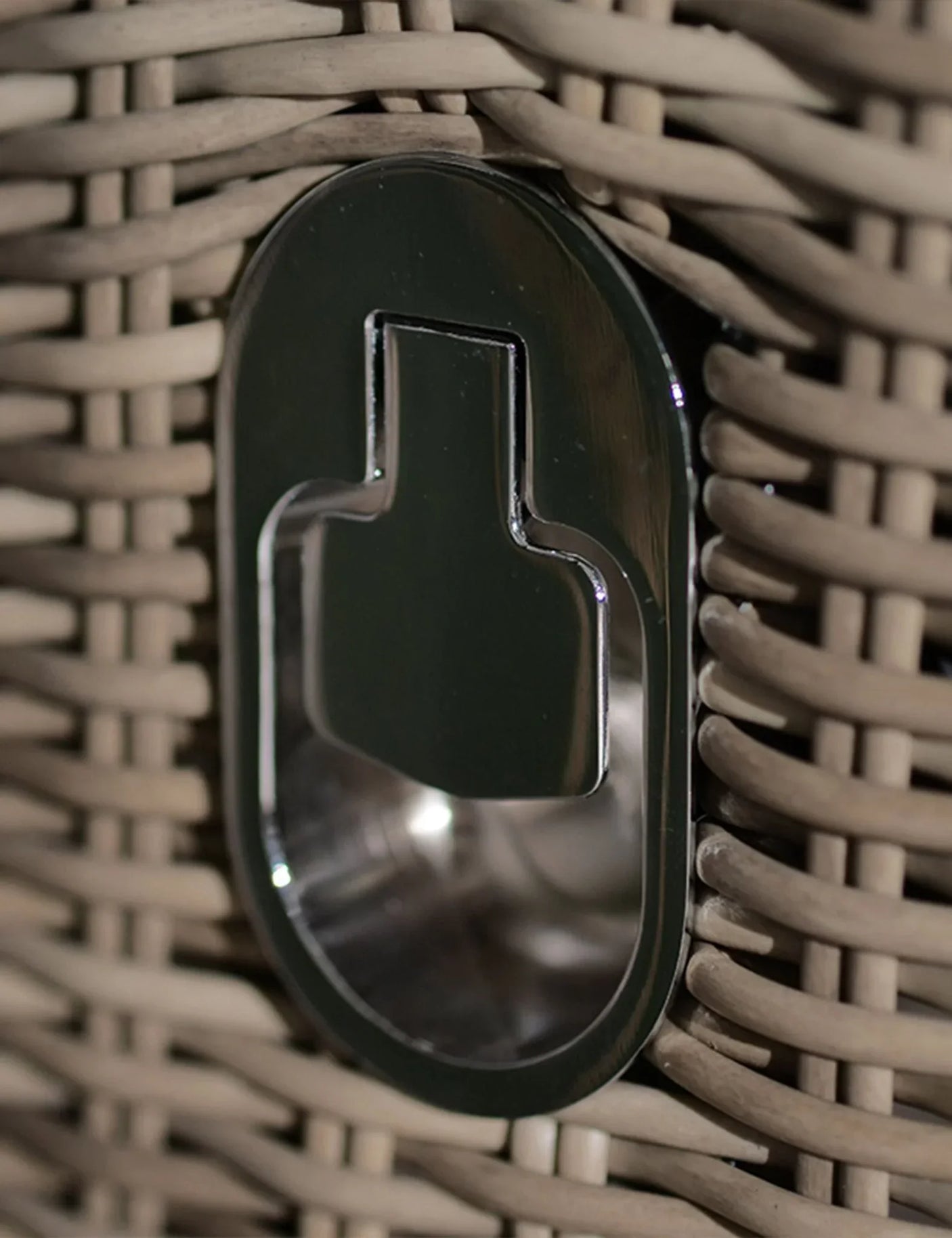 Close-up of rattan garden furniture with integrated metal bottle opener feature