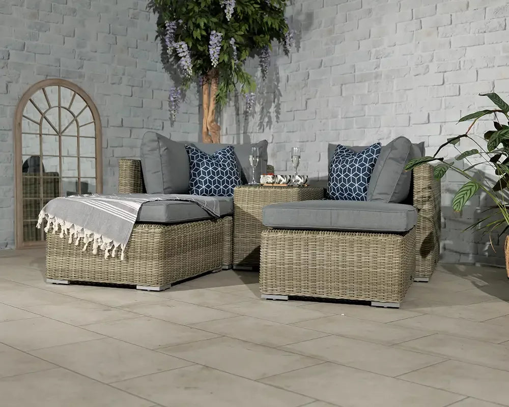 Grey rattan corner sofa set with cushions and coffee table on tiled patio