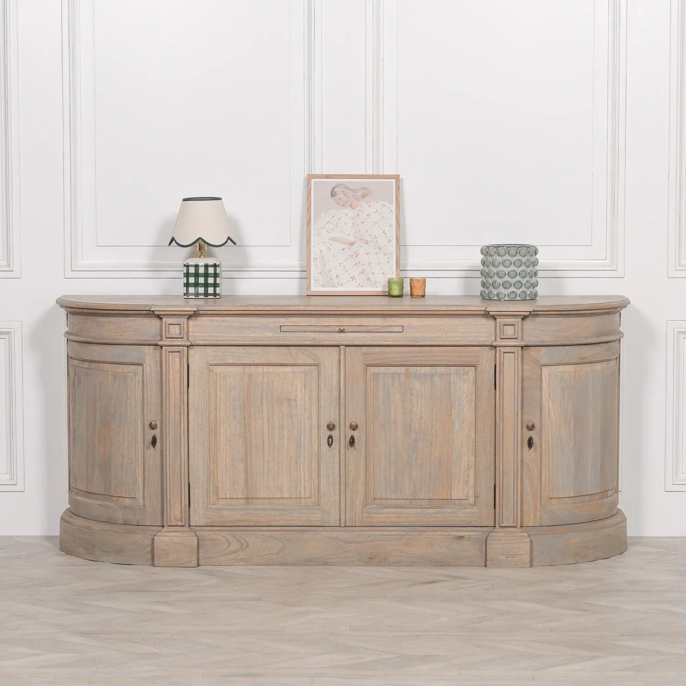 Oak sideboard with four cabinet doors, curved edges, lamp and decor on top