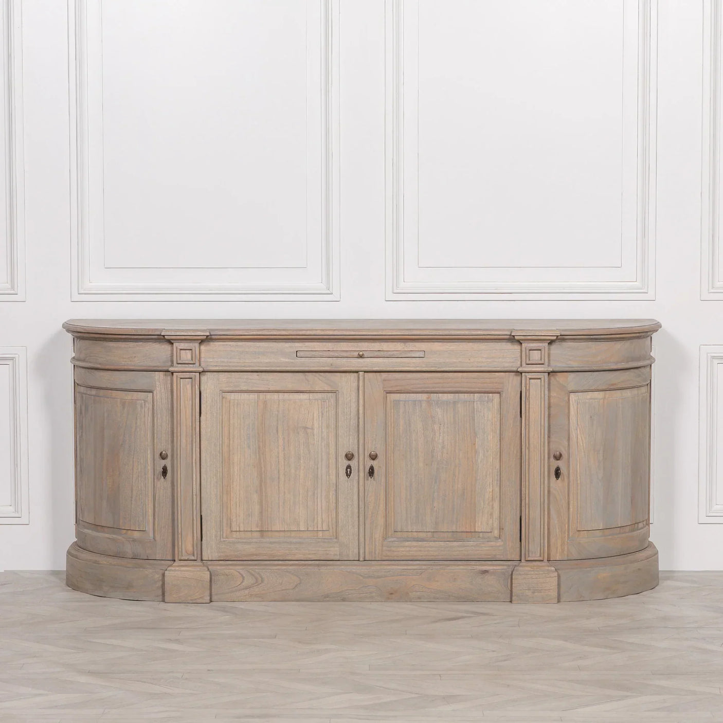 Large oak sideboard with curved corners, paneled doors and storage, set against white wall