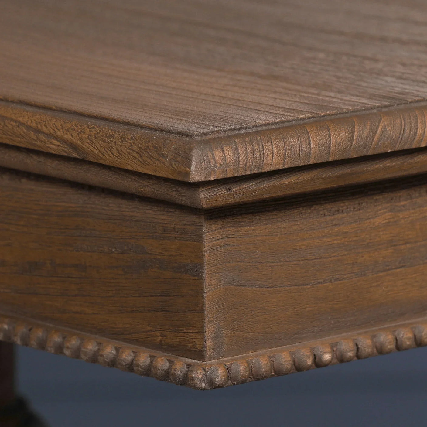 Close-up of wooden coffee table corner with textured trim and natural grain finish