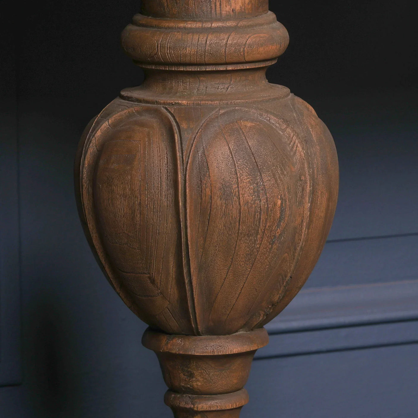Carved solid wood furniture leg with decorative grooves and natural brown finish