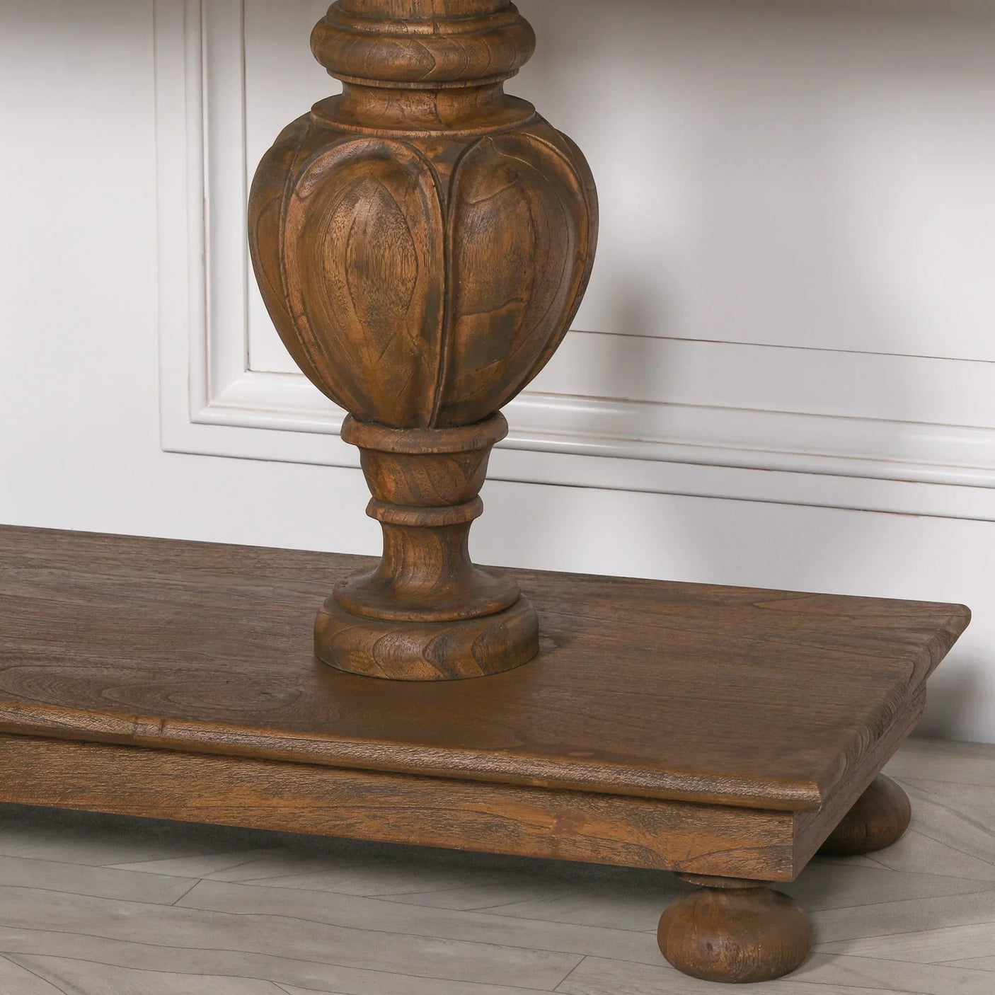 Carved wood table leg on rectangular oak base with decorative ball feet