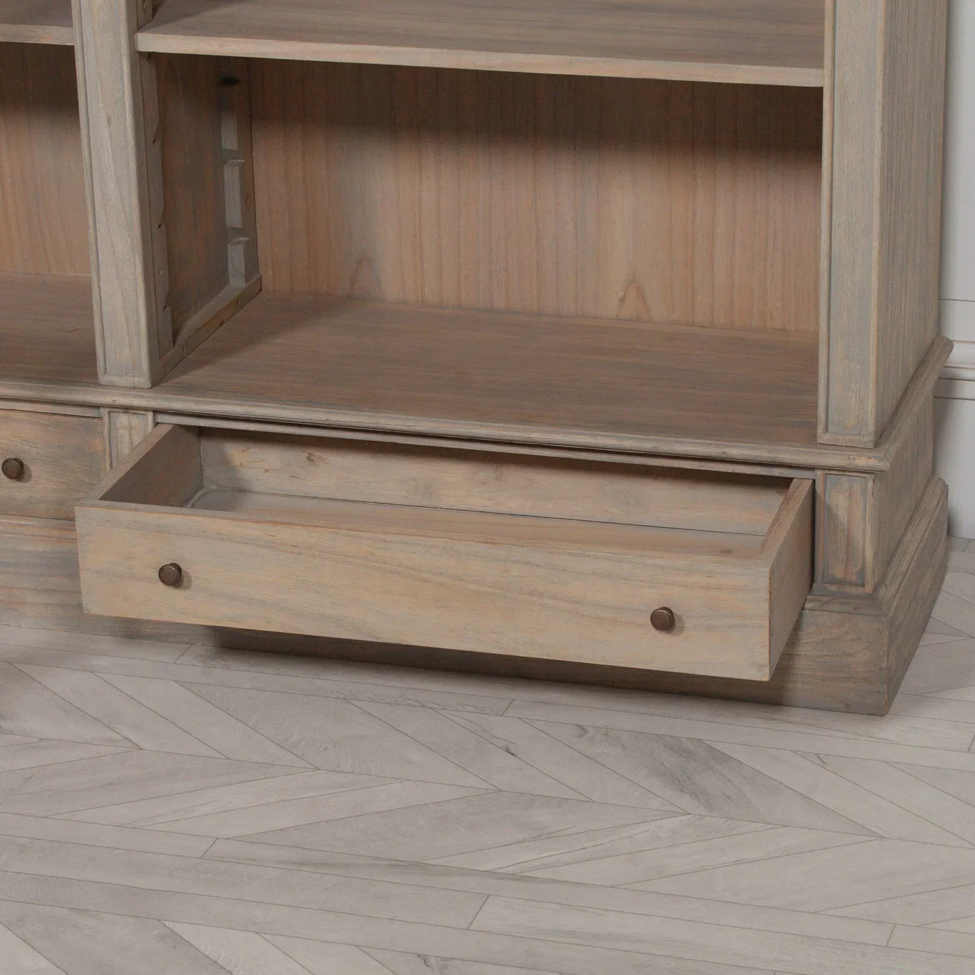 Oak wood bookcase lower shelf with open storage drawer and round metal handles
