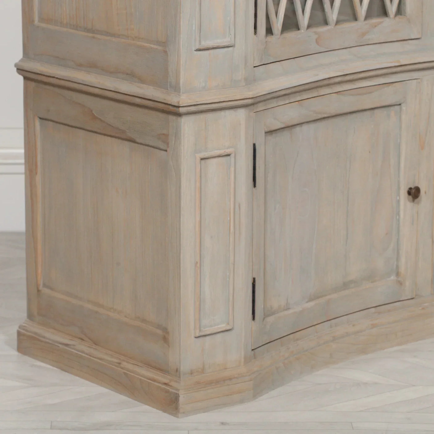 Wooden corner cabinet with panel detailing and lower storage door in light finish