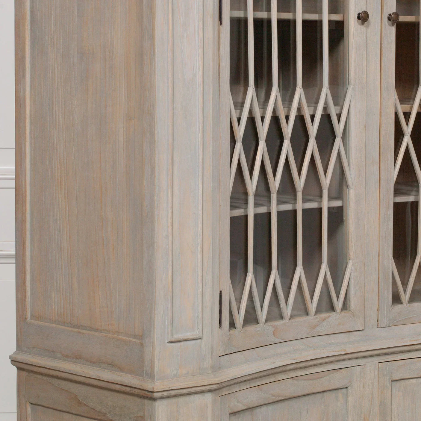 Close up of wooden display cabinet with glass doors and diamond lattice detailing