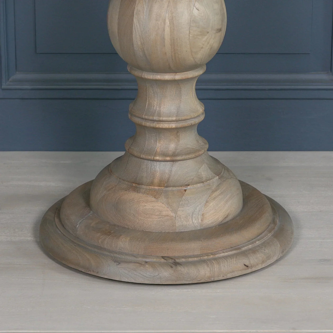 Rustic wooden dining table pedestal base with round shape and smooth finish on light floor