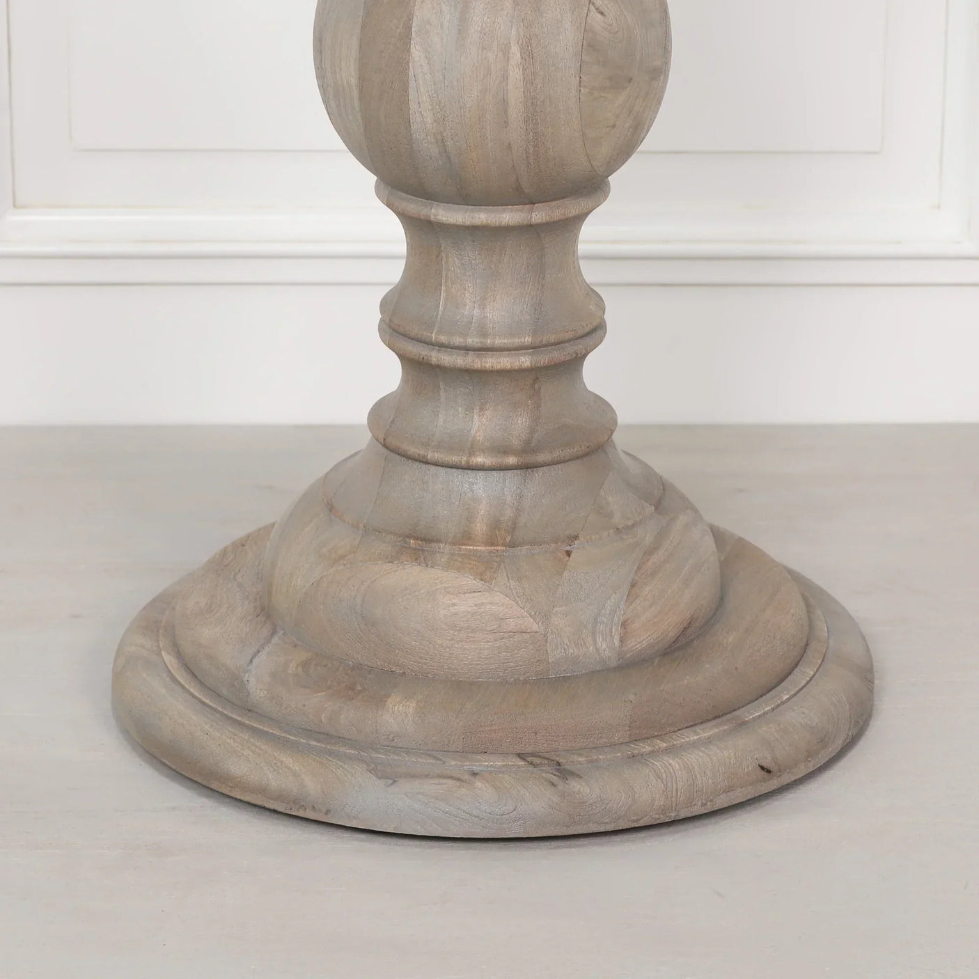 Solid wood dining table pedestal base with natural finish, close-up detail view