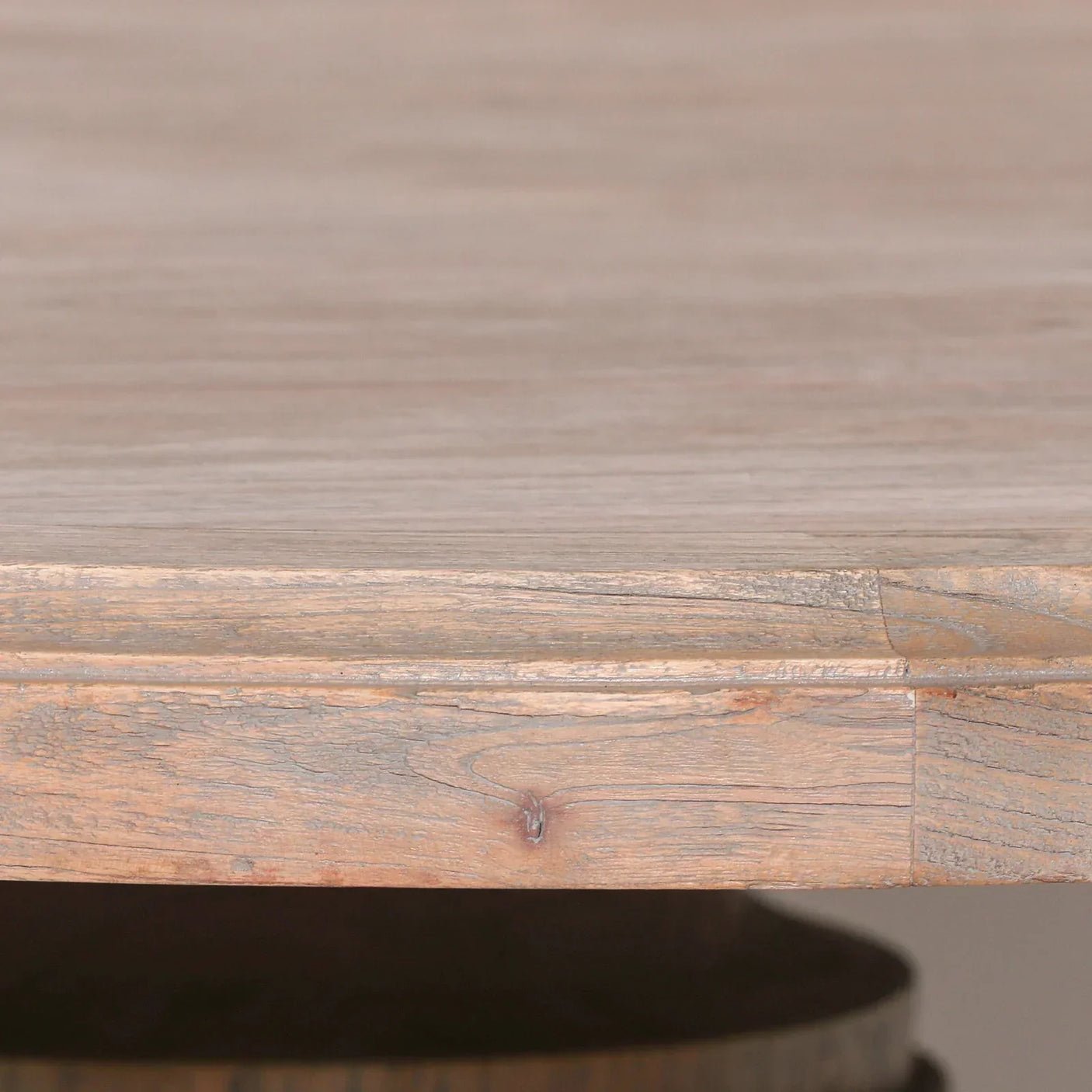 Close-up of natural wood dining table edge showing grain and rustic texture